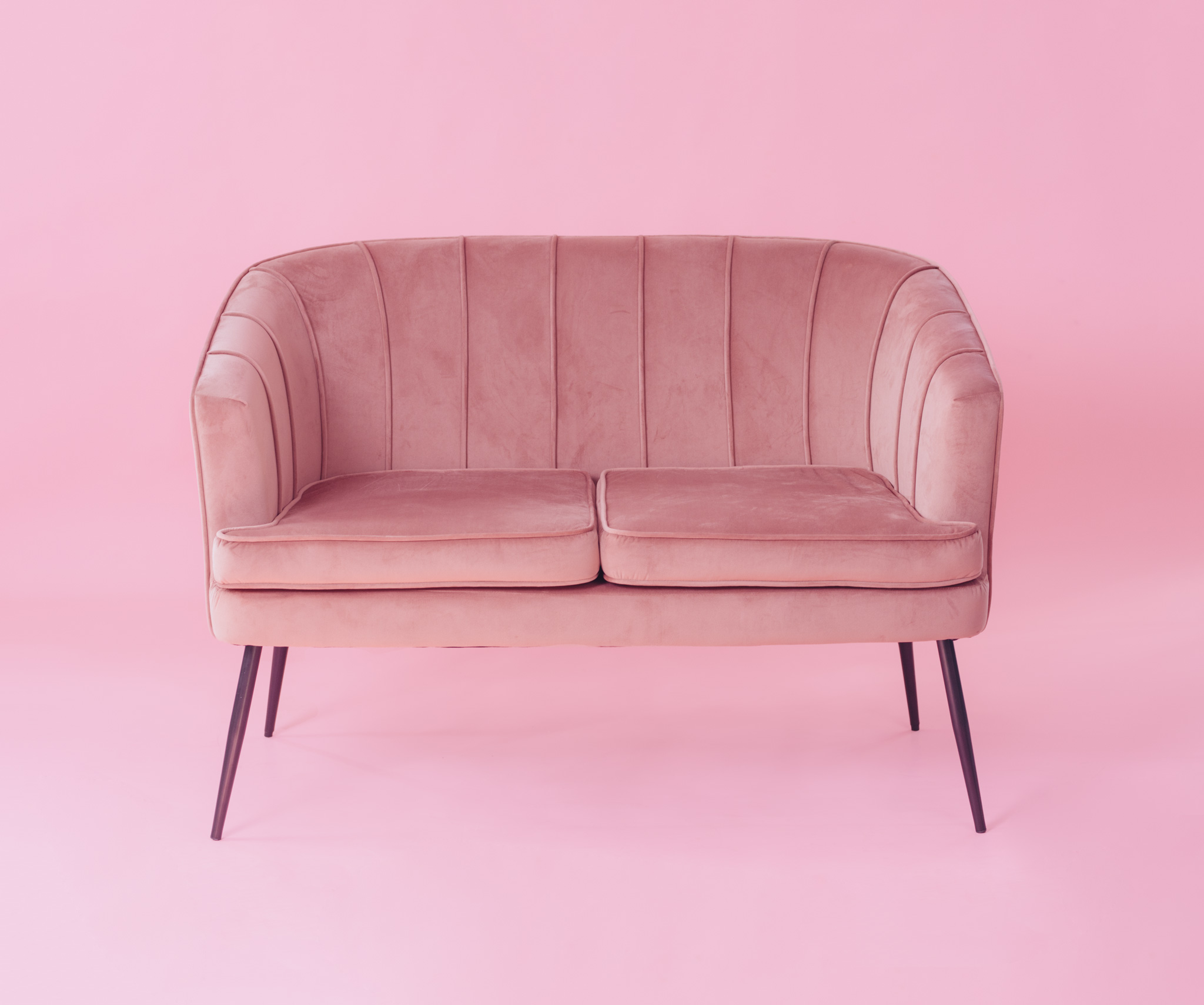 Różowa sofa na różowym tle wpisująca się w Barbie trend
